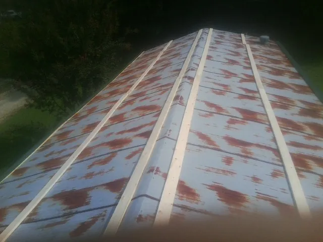 Rusted metal roof panels with new wood purlins before replacement — Storm Damage Roof Repair in Center Harbor by Roofing Brothers
